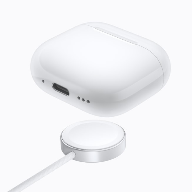 AirPods 5 med trådløst ladeetui over en lader